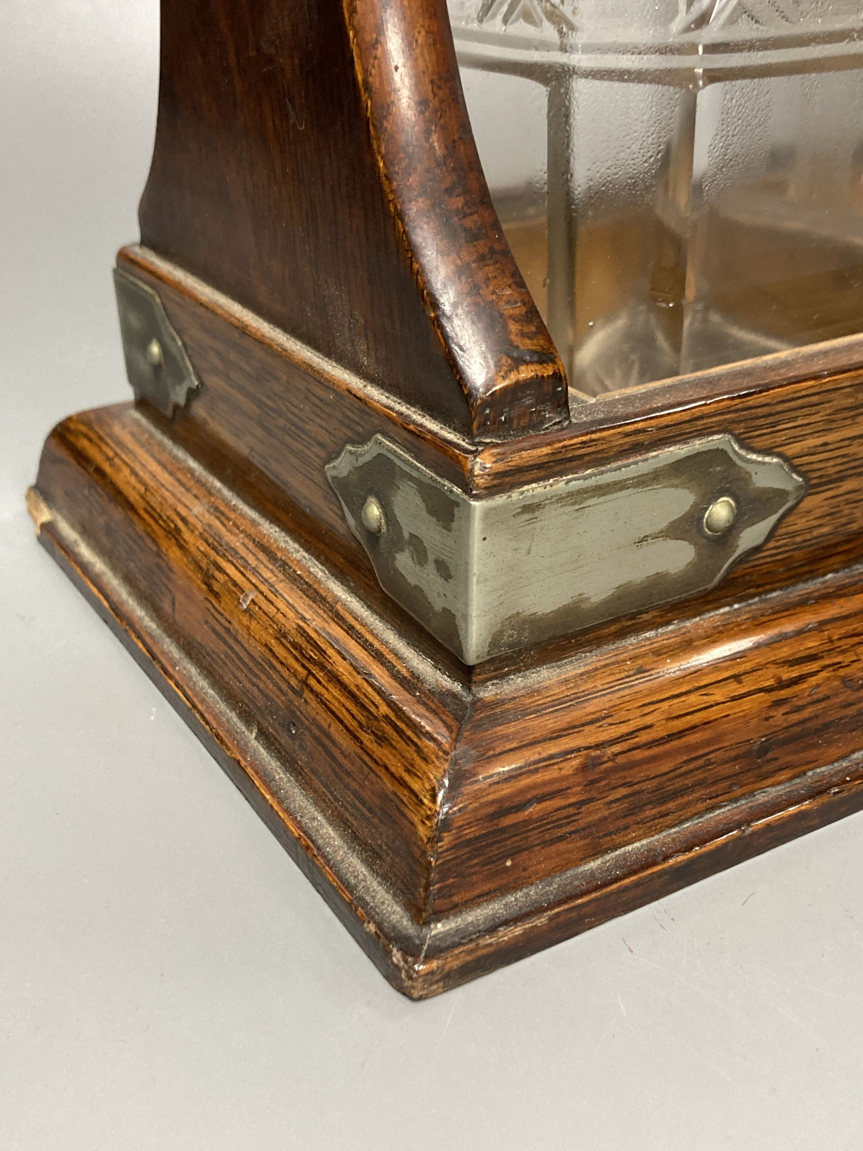 An Edwardian oak three decanter tantalus